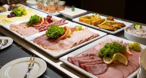 um buffet com muitos tipos diferentes de carnes e vegetais em PLAZA Premium Columbus Bremen em Bremen