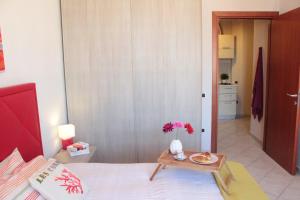 ein Schlafzimmer mit einem Bett und einem Tisch mit einer Blumenvase in der Unterkunft Casa Tiziano in Cagliari