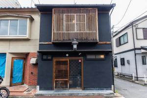 a black building with a balcony on top of it at Shiki Homes HIGOYA 肥後屋 in Kyoto