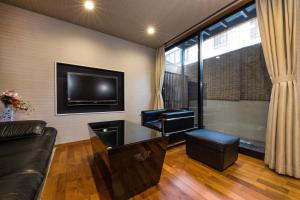 a living room with a couch and a tv at Shiki Homes HIGOYA 肥後屋 in Kyoto +26 photos