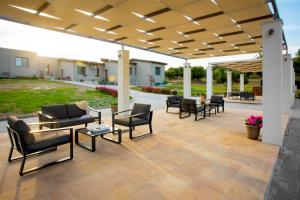 a patio with couches and tables and chairs under a pavilion at Alikon Adult-Only in Neos Marmaras