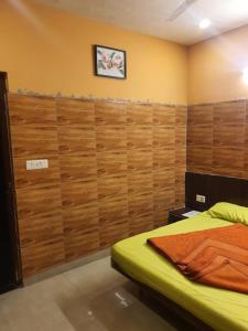 Un dormitorio con una cama y una pared de madera. en HOTEL YUVRAJ, en Haldwāni