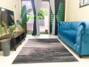 a blue couch in a living room with a tv at Sulong Inn - Private Pool Homestay in Kuantan, Pantai Sepat in Kuantan