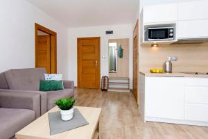 ヤスタルニャにあるmikroKlimat IIのリビングルーム(ソファ、テーブル付)、キッチンが備わります。