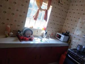 encimera de cocina con fregadero y ventana en La petals hideaway house-Machakos en Machakos