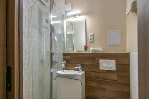 a bathroom with a sink and a shower at Vénusz Hotel in Siófok