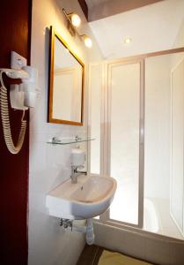 ein weißes Waschbecken im Bad mit Fenster in der Unterkunft Teátrum Boutique Hotel in Győr