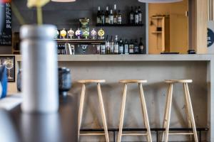 a bar with three wooden stools at a counter at Airport Hotel, Billund in Billund