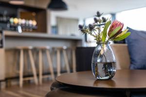 a vase filled with flowers sitting on a table at Airport Hotel, Billund in Billund