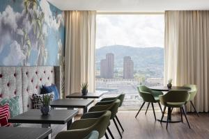 un ristorante con tavoli e sedie e una grande finestra di Renaissance Zurich Tower Hotel a Zurigo