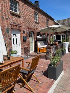 a patio with a table and chairs and an umbrella at Burghaus 5 in Greetsiel