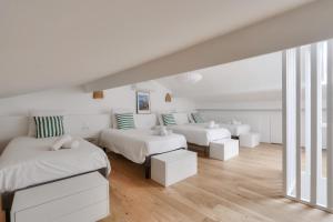 a white bedroom with two beds and a couch at Nocnoc - Le Nid in Marseille
