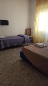カリアリにあるB&B Argentiera 12のベッド2台とテレビが備わるホテルルームです。
