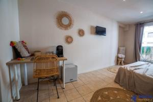 sypialnia z biurkiem, łóżkiem i lustrem w obiekcie Chambre 1 René Cassinbalcon Wifi Mini-frigo TV w Nicei