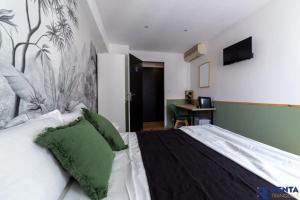 a bedroom with a large bed with a green pillow at Room Riviera 3 Aéroport Wifi Climatisation in Nice