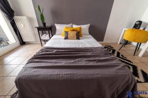 a large bed in a room with a yellow chair at Chambre 2 René Cassinbalcon Wifi Mini-frigo TV in Nice