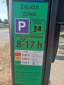 a parking meter with a price sign on it at City Center Apartment in Siauliai in Šiauliai
