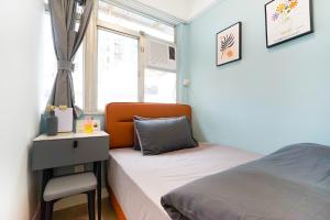 a bedroom with a bed and a desk and a window at Student Accommodation - Lockhart Road 137 in Hong Kong