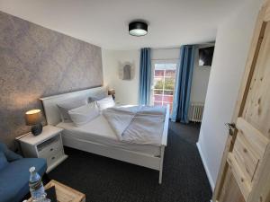 a bedroom with a white bed and a window at Hotel Schleimünde in Kappeln