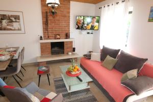 salon z czerwoną kanapą i kominkiem w obiekcie House Zbasnik w mieście Klimno