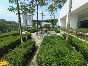 a garden with bushes and trees and a building at Medic Homestay Selayang Residence 280 in Batu Caves