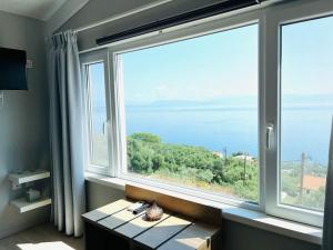 Habitación con ventana grande con vistas al océano. en Green Horizon 3 BR House with Sea View en Benitses