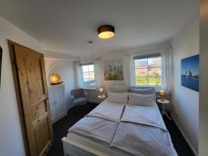 ein Schlafzimmer mit einem Bett und zwei Fenstern in der Unterkunft Hotel Schleimünde in Kappeln