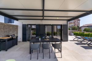 a patio with a black table and chairs at Villa Bella in Klimno
