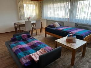 ein Wohnzimmer mit 2 Betten und einem Tisch in der Unterkunft Ferienwohnung Makar in Burladingen