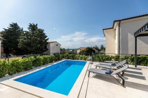 una piscina con panchina accanto a una casa di Villa Bella a Klimno