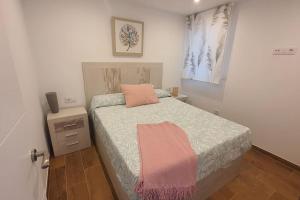 um quarto com uma cama com um cobertor rosa em HyP - A casa da Fina em Miño