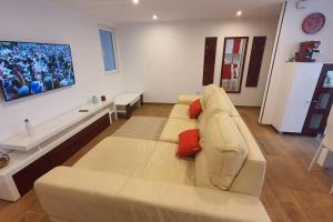 uma sala de estar com um sofá branco com almofadas vermelhas em HyP - A casa da Fina em Miño