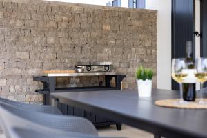 a table with chairs and a grill in front of a brick wall at Villa Bella in Klimno
