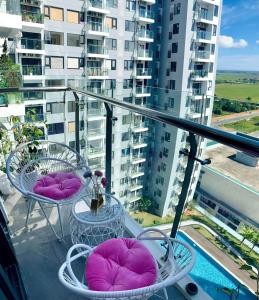 - un balcon avec des oreillers et des tables violets dans un bâtiment dans l'établissement Uyên Homestay, à Thôn Văn Dương