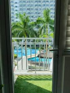 een raam met uitzicht op het zwembad bij Condo Near MOA Shell Residence Pool View Netflix DisneyPlus in Manilla