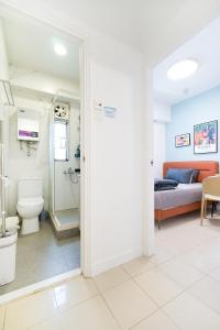 a bathroom with a toilet and a bed in a room at Student Accommodation - Lockhart Road 137 in Hong Kong