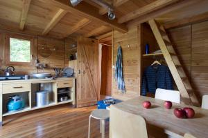 eine Küche mit Holzwänden und einem Tisch mit Äpfeln darauf in der Unterkunft Village Huttopia Senonches - Perche in Senonches