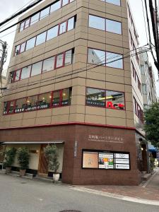 a large building with windows on a city street at Sweet House Umeda Minami in Osaka