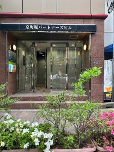an entrance to a building with flowers in front of it at Sweet House Umeda Minami in Osaka