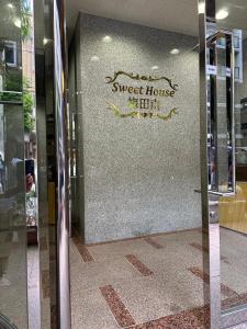 a glass door with a sweet house sign on a wall at Sweet House Umeda Minami in Osaka