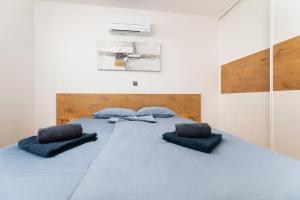 una camera da letto con un grande letto blu con due cuscini di Villa Bella a Klimno Altre 42 foto