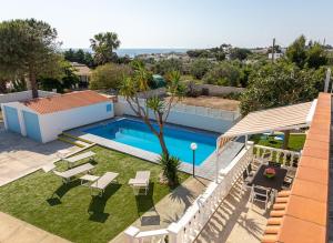 a backyard with a swimming pool and lawnitures at Villa Gina in Capilungo