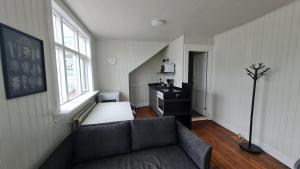 a living room with a couch and a desk and window at Downtown Guesthouse Reykjavik in Reykjavík