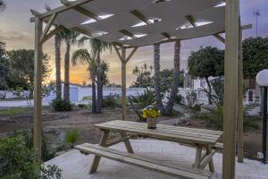 a picnic table under a pergola with flowers on it at Villa Gina in Capilungo