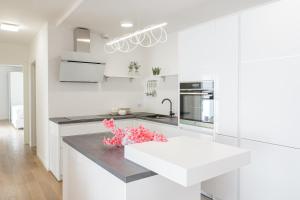 a white kitchen with a large white counter top at The Residence Dubrovnik in Dubrovnik +16 photos