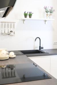 a white kitchen with a sink and some dishes at The Residence Dubrovnik in Dubrovnik