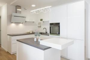 a white kitchen with white cabinets and a sink at The Residence Dubrovnik in Dubrovnik