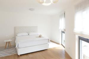 a white bedroom with a white bed and a chandelier at The Residence Dubrovnik in Dubrovnik