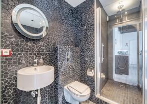 uma casa de banho com um lavatório, um WC e um espelho. em Ingolfsstræti Apartments by Heimaleiga em Reykjavík