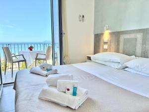 una camera d'albergo con due letti e asciugamani di Hotel Marconi a Sperlonga